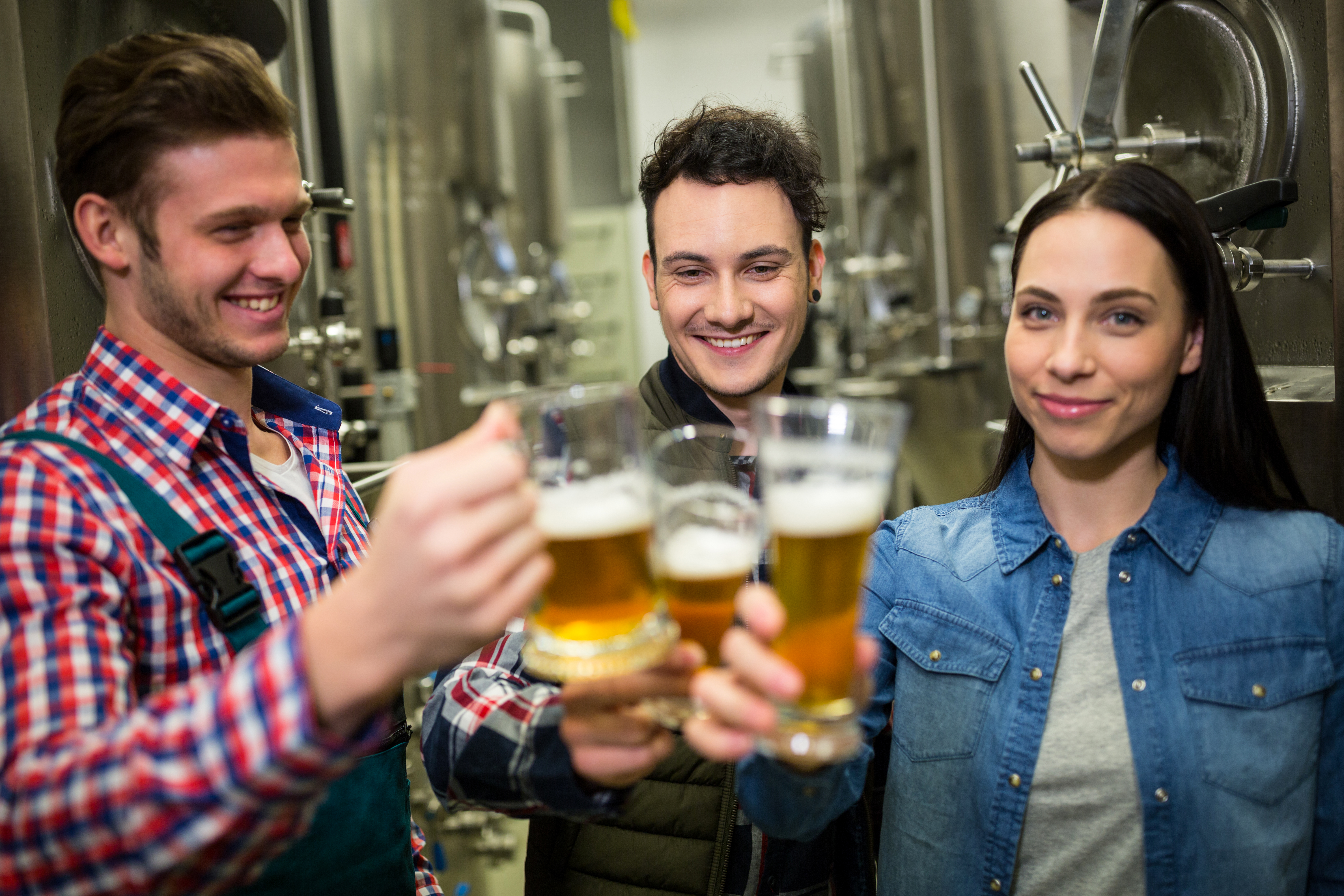 Brewers toasting beers at brewery factory