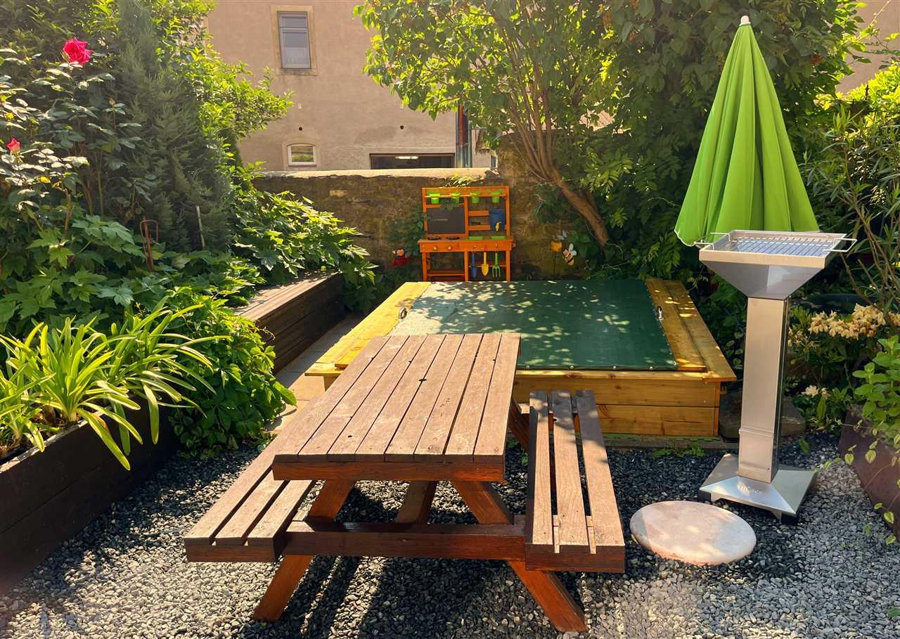 Sandkasten und Grill im Garten