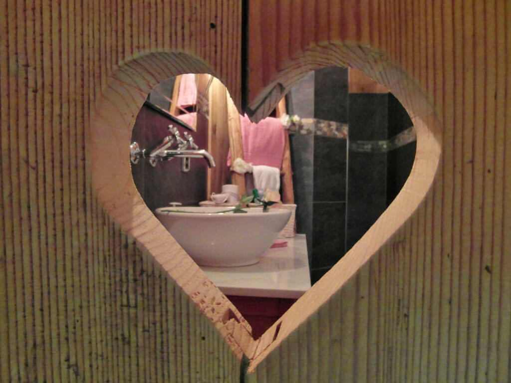 Blick durch Holzherz ins Badezimmer