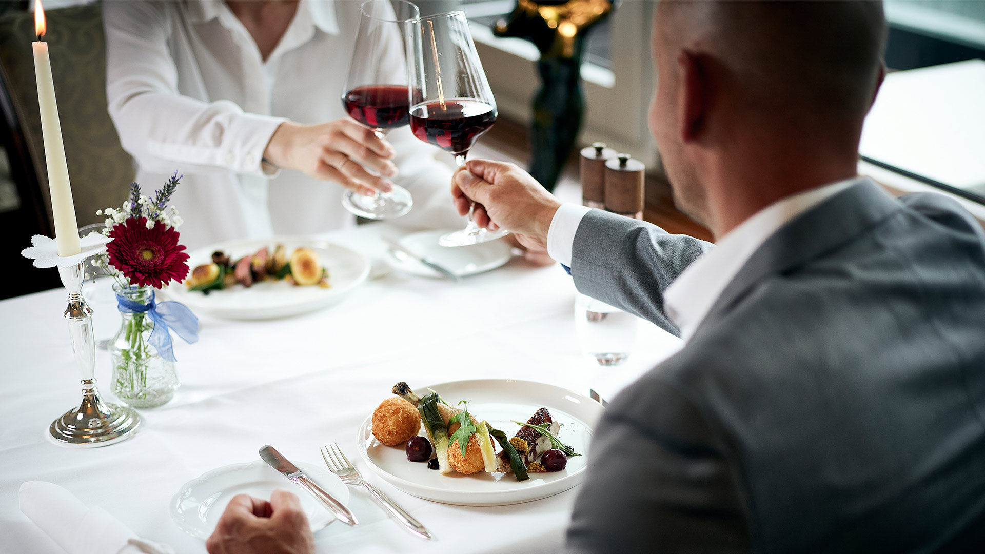 restaurant-belvedere-spiez-gaeste-wein-anstossen-essen-kerze-blumen.jpg